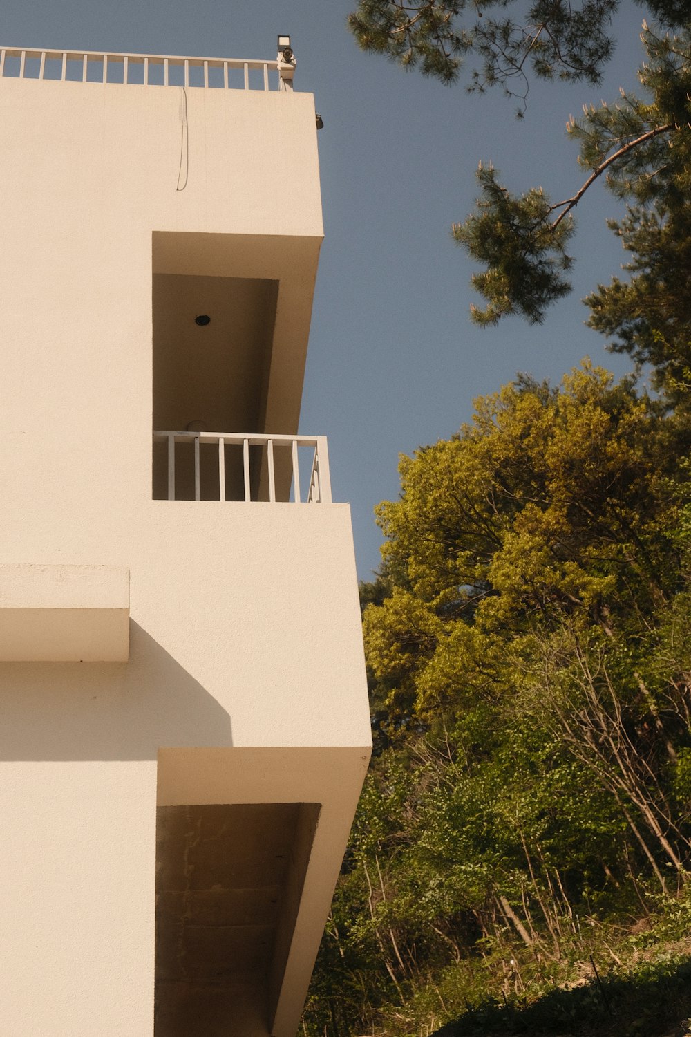 a tall white building with a balcony and balconies