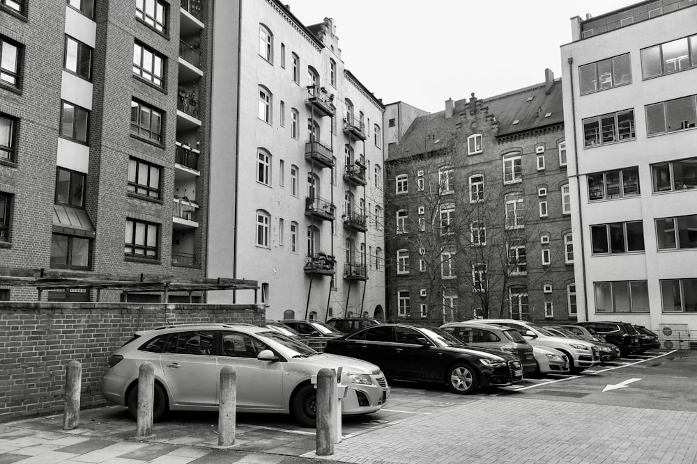 a row of parked cars sitting next to tall buildings