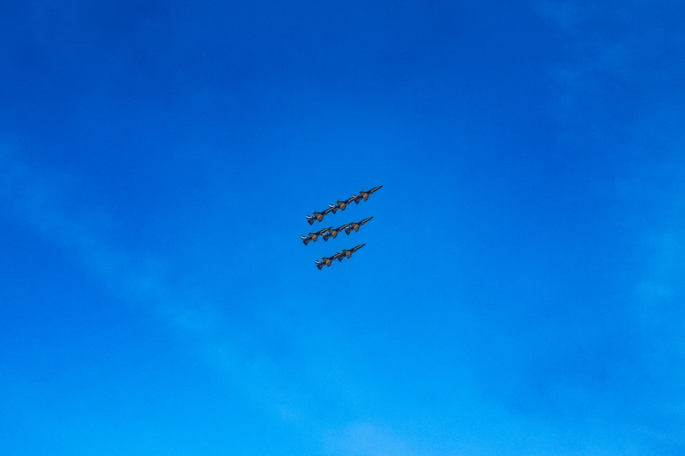 a group of airplanes flying through a blue sky