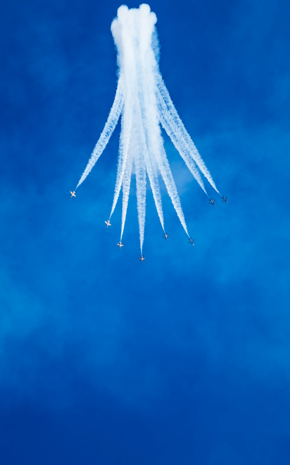 a group of jets flying through a blue sky