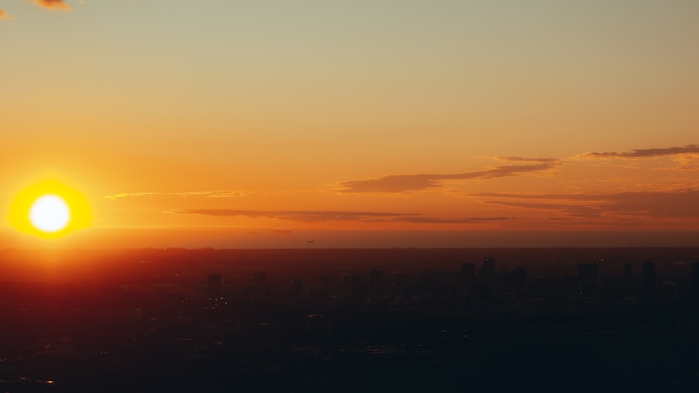 the sun is setting over a city skyline