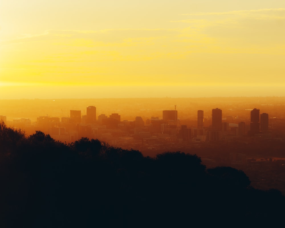 a view of a city from a hill at sunset