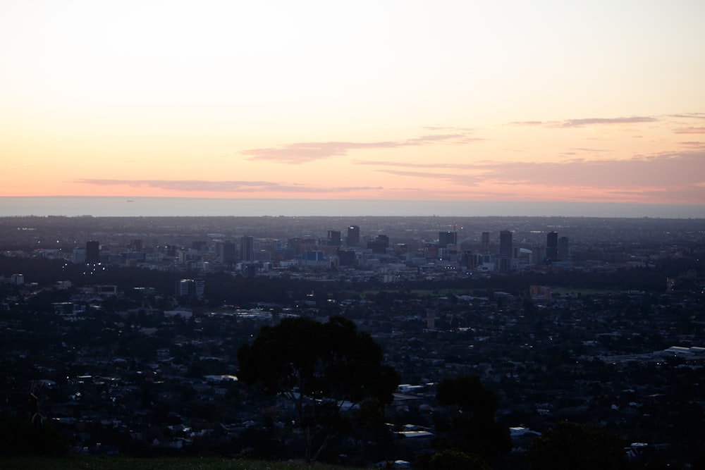 a view of a city at sunset from a hill