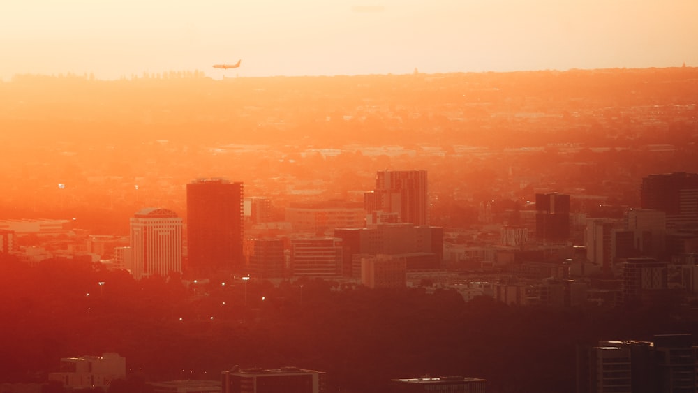 a city skyline with a plane flying over it