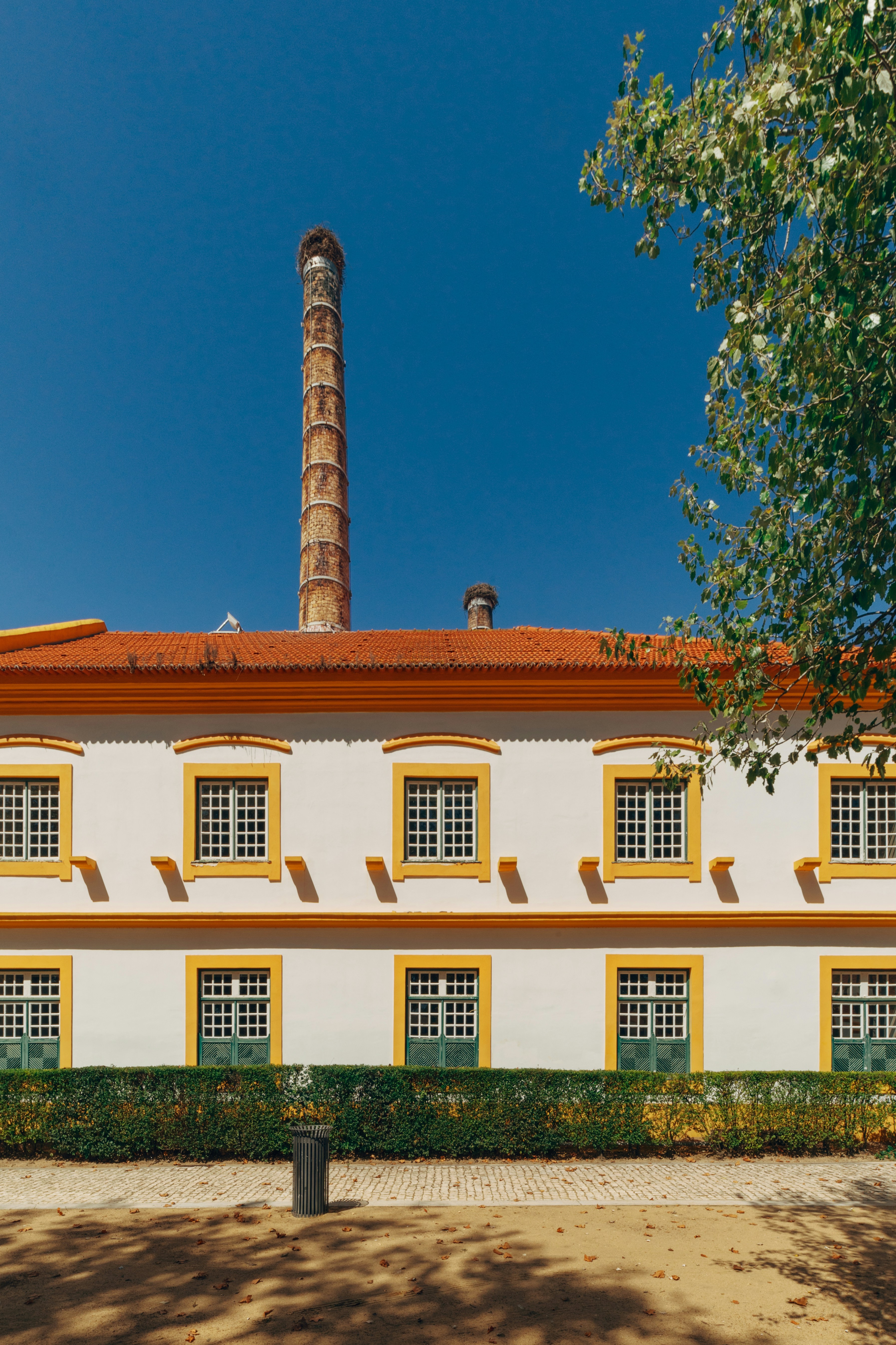 a white building with yellow windows and a red roof