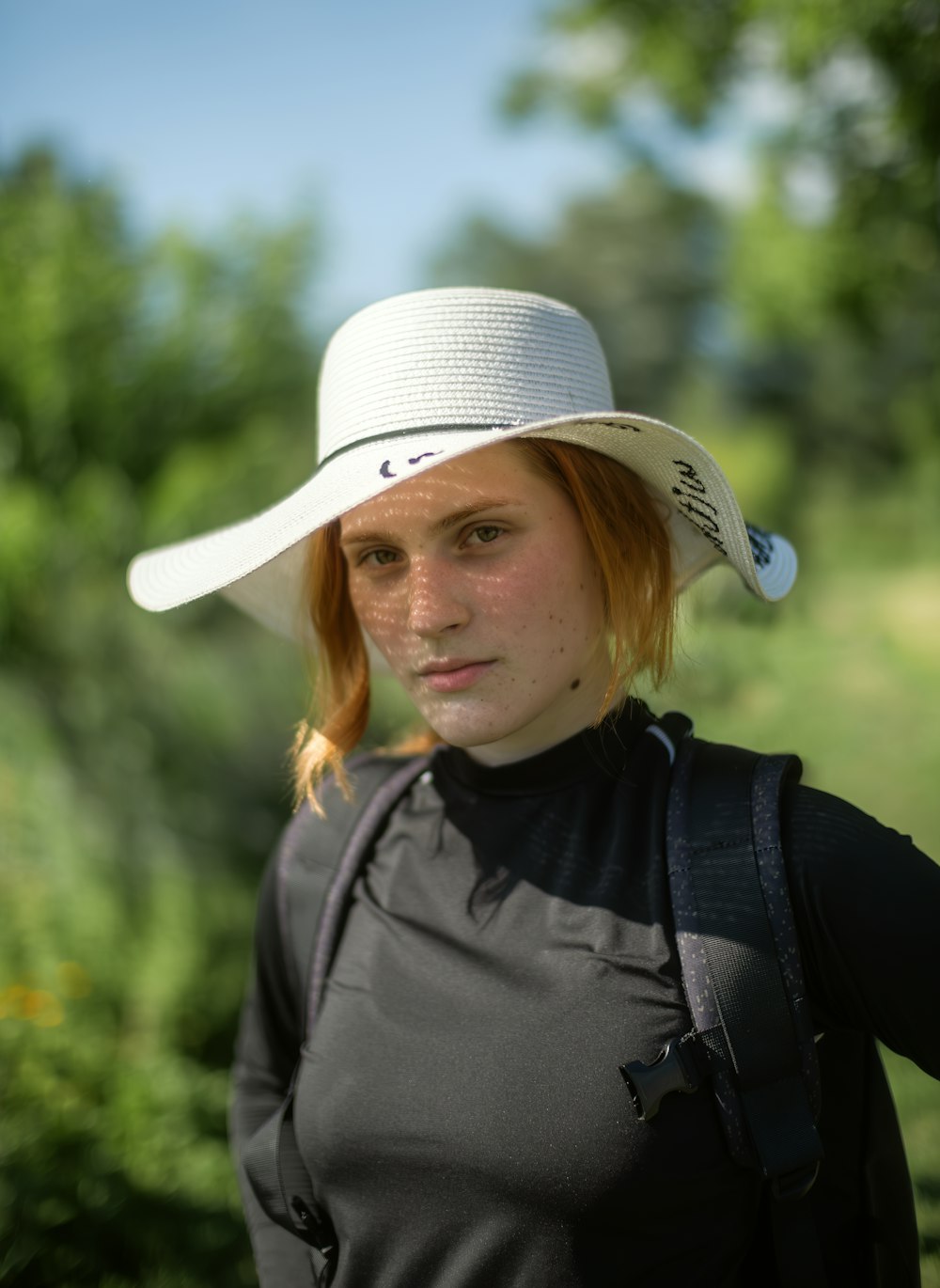 a woman wearing a white hat standing in a field