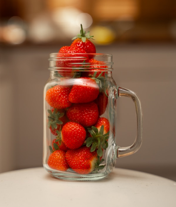 Close-up of a jar of traditional Spanish strawberry jam with fresh strawberries around it