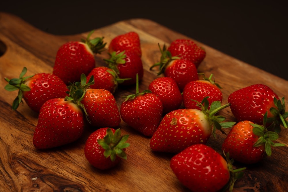 a bunch of strawberries sitting on a cutting board