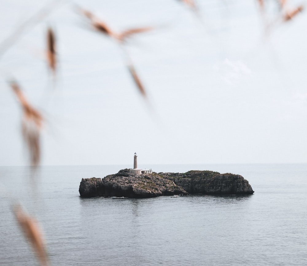 a lighthouse on a small island in the middle of the ocean