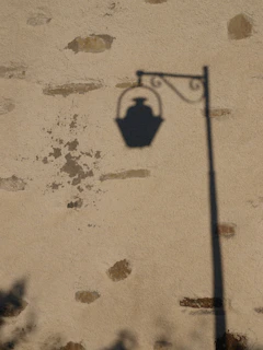 A close-up shot of a vintage film light casting dramatic shadows on a textured wall.