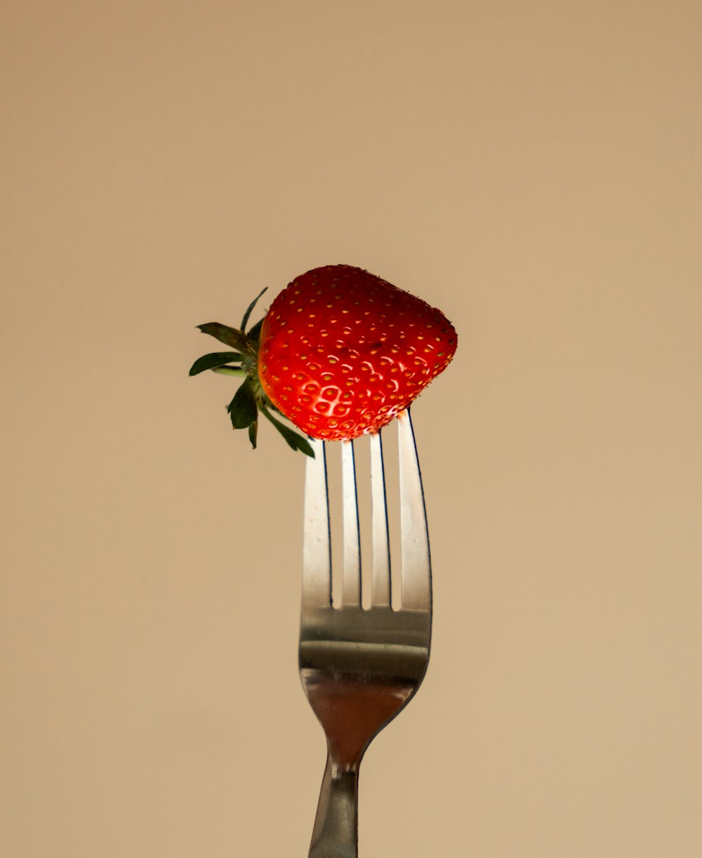 une fourchette avec une fraise sur le dessus