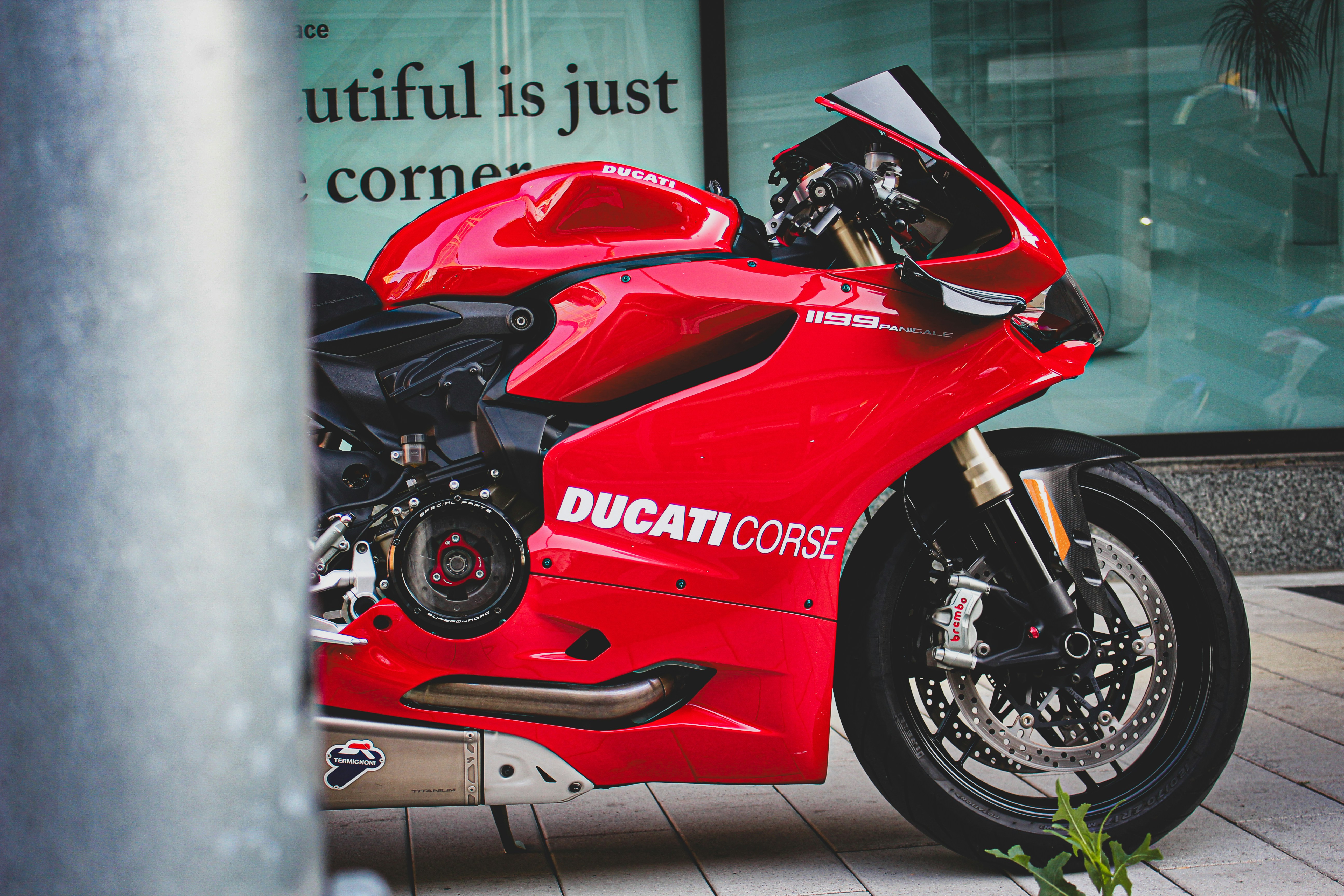 a red motorcycle parked in front of a building
