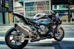 A motorcycle equipped with stylish blue and black accessories parked on a city street