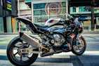 A motorcycle equipped with stylish blue and black accessories parked on a city street