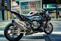 Close-up of a sleek blue motorcycle parked on a city street.