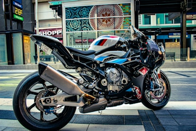 Close-up of a sleek blue motorcycle parked on a city street.