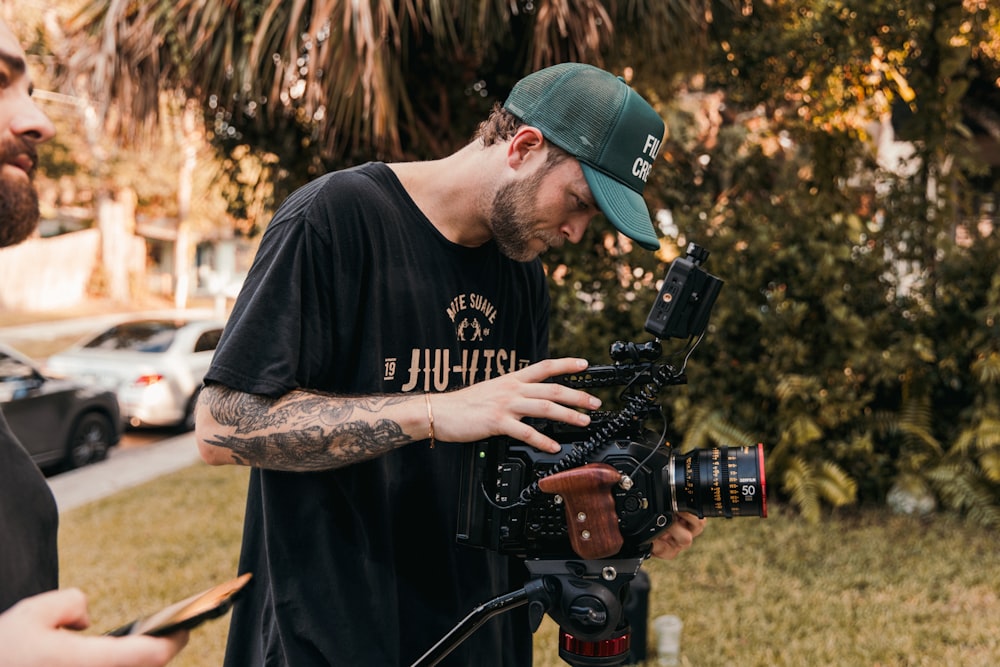 Un uomo che tiene una macchina fotografica davanti a una telecamera