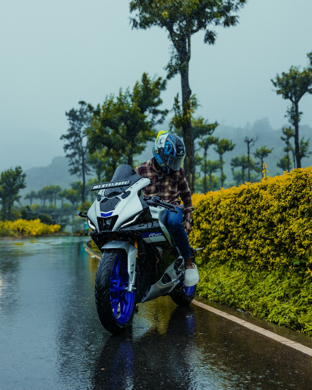 a person riding a motorcycle on a wet road