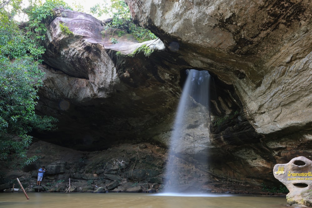 a man standing in front of a waterfall