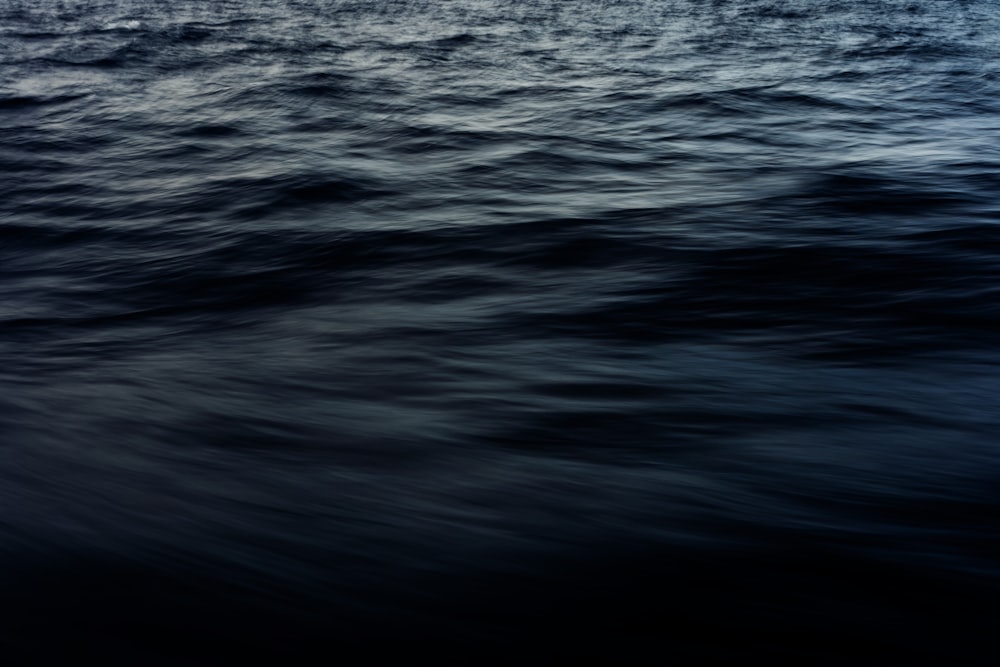 a large body of water with a boat in the distance