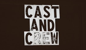 a black and white photo of a sign that says cast and crew