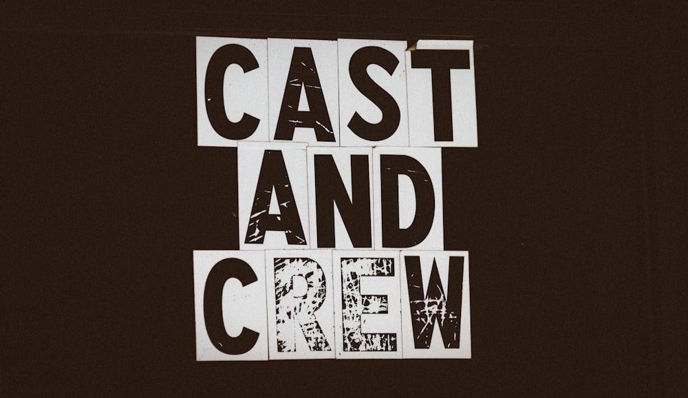 a black and white photo of a sign that says cast and crew