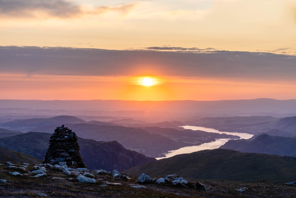 the sun is setting over a mountain range