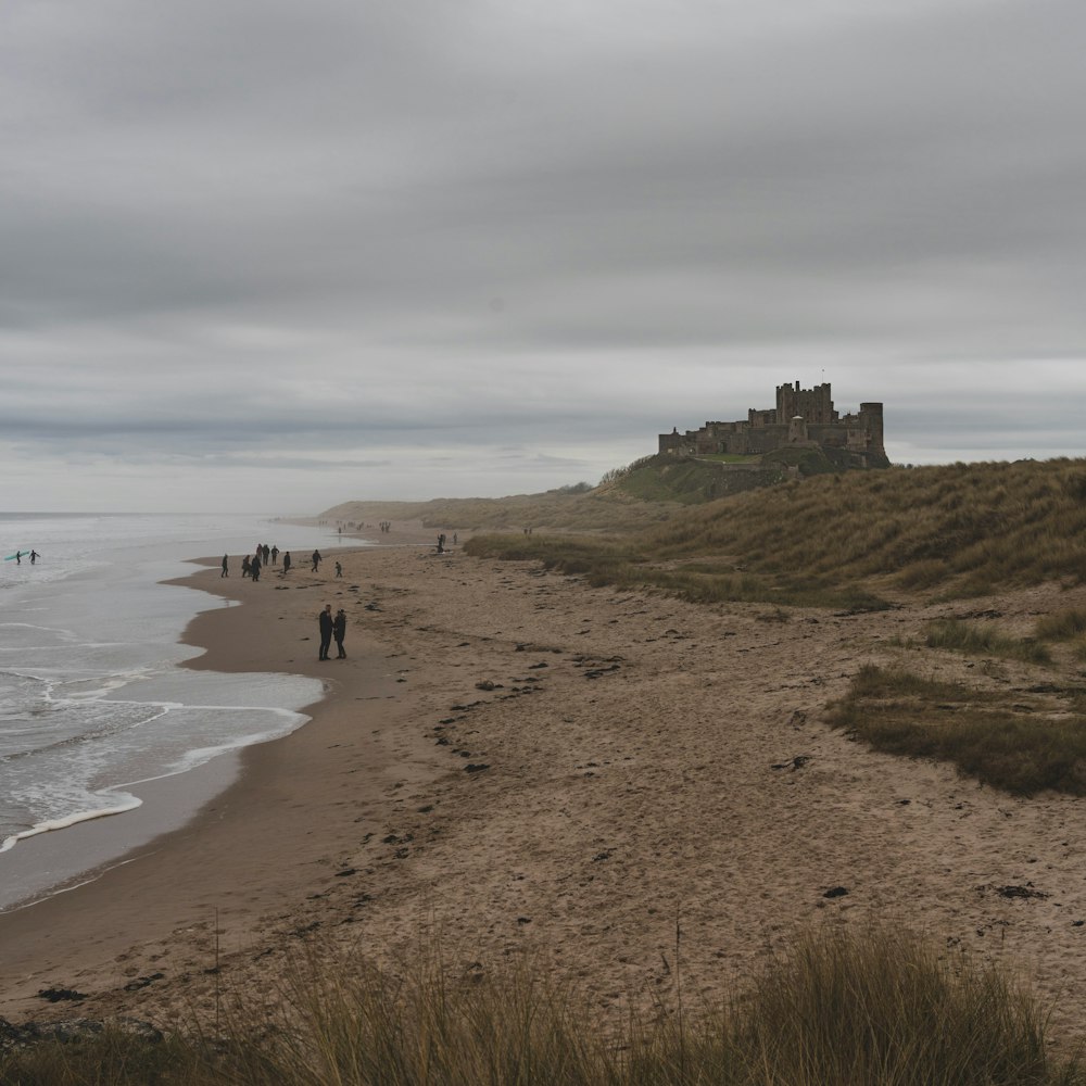 a group of people standing on top of a sandy beach