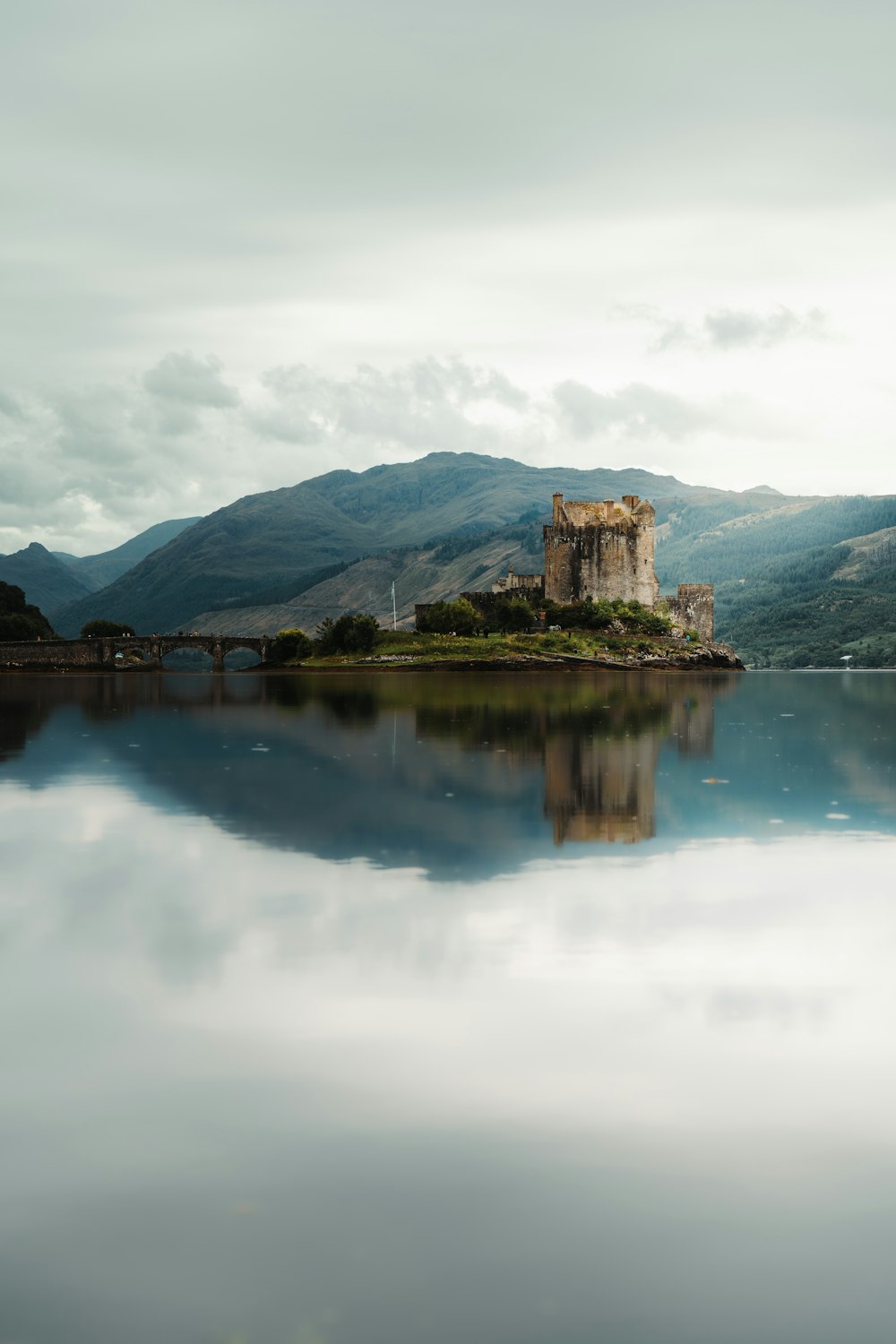 a castle sits on a small island in the middle of a lake