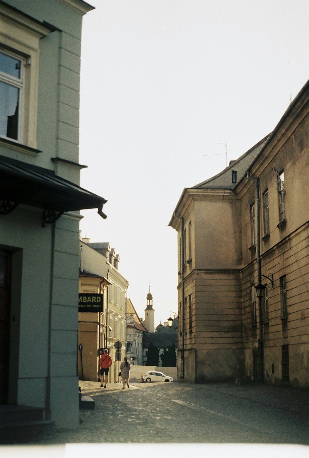 a person walking down a street next to tall buildings