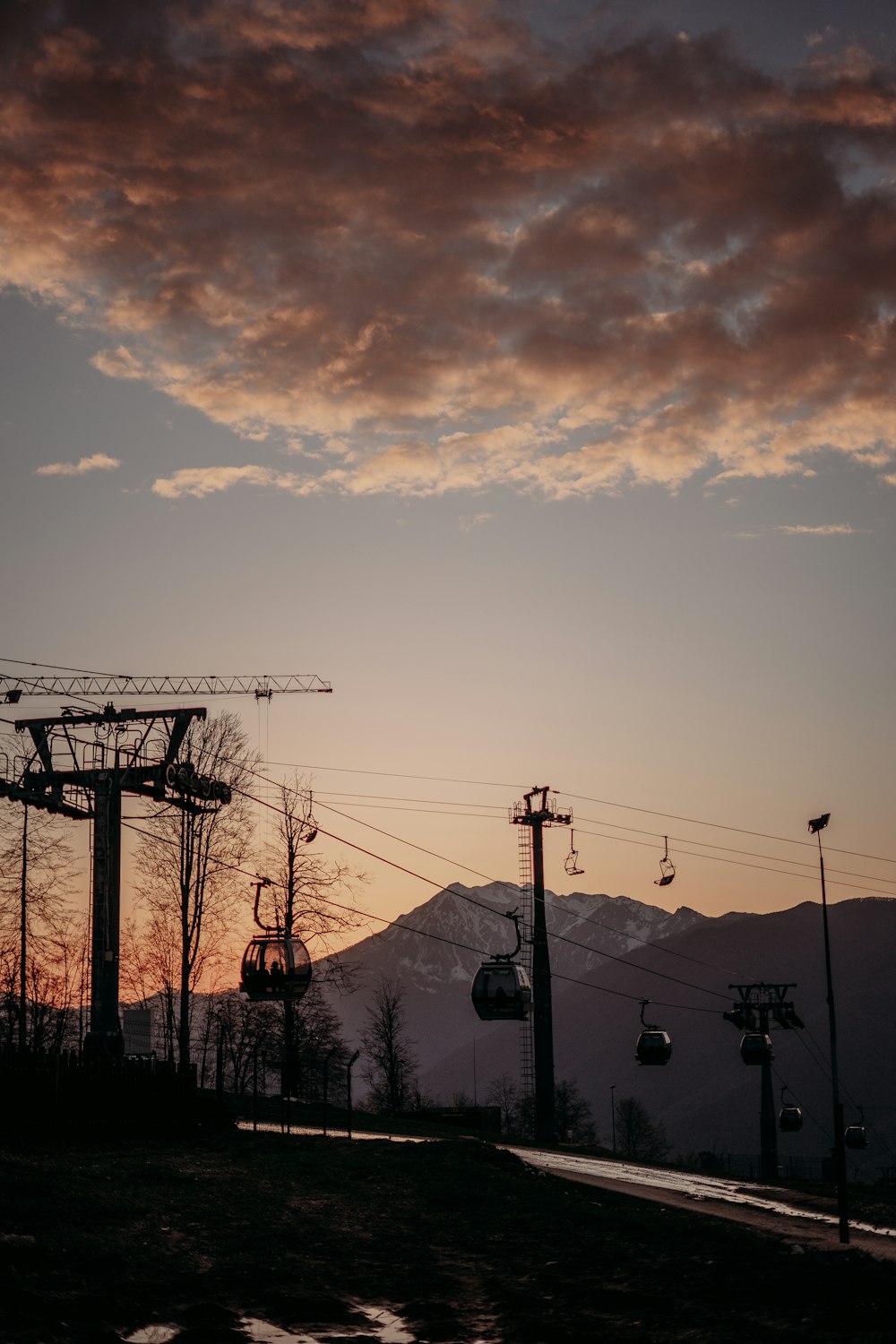 a ski lift at sunset with a mountain in the background