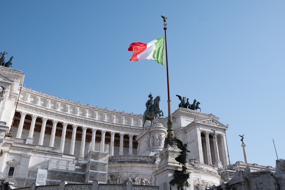 a flag flying in the wind in front of a building