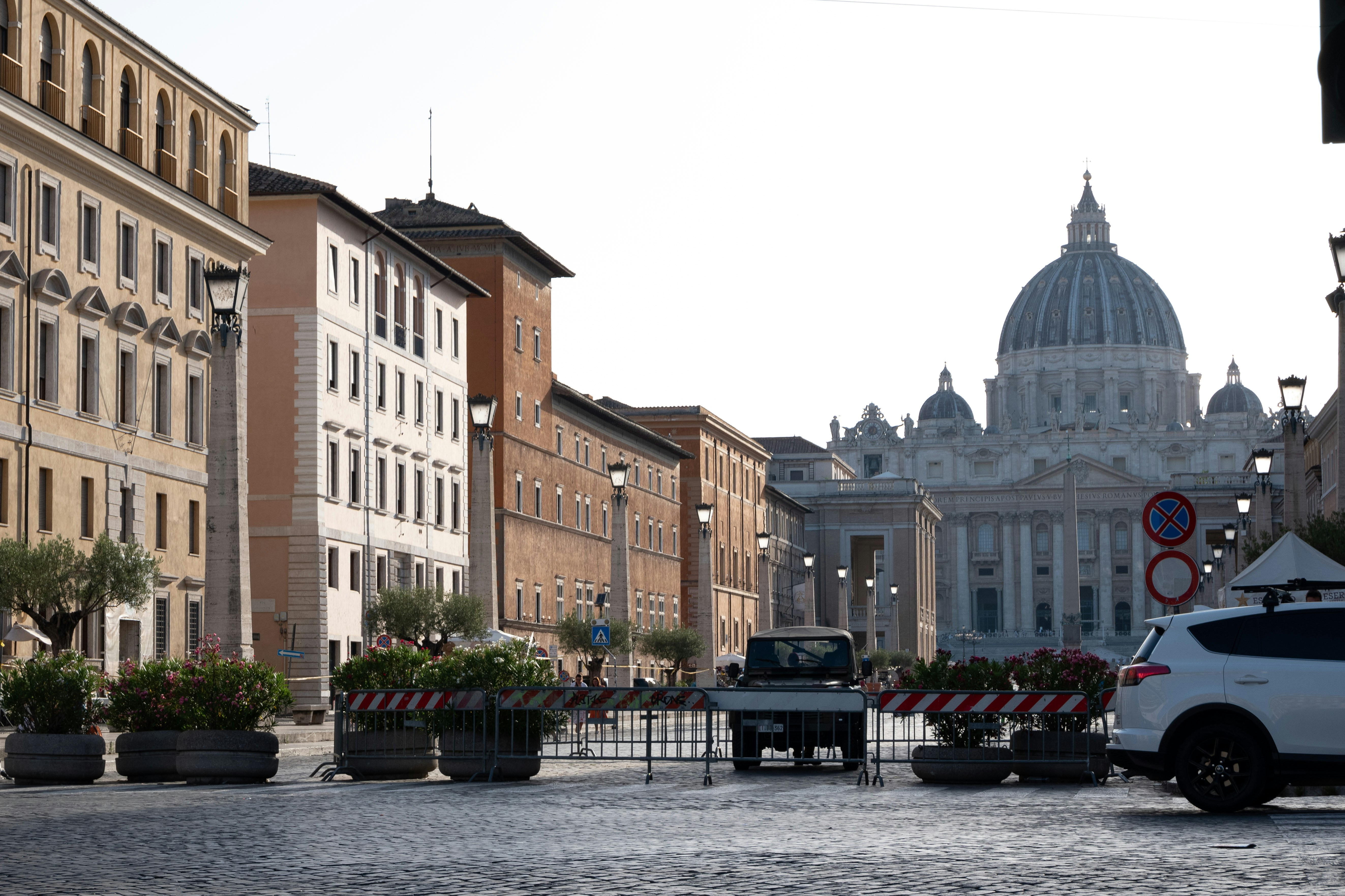 a white car driving down a street next to tall buildings