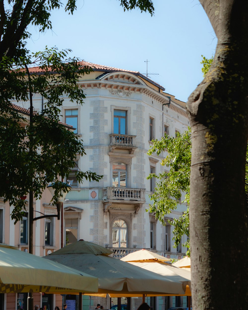 a group of people sitting under umbrellas in front of a building