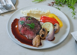 Close-up of a perfectly plated filet mignon with fresh herbs at zanhié.