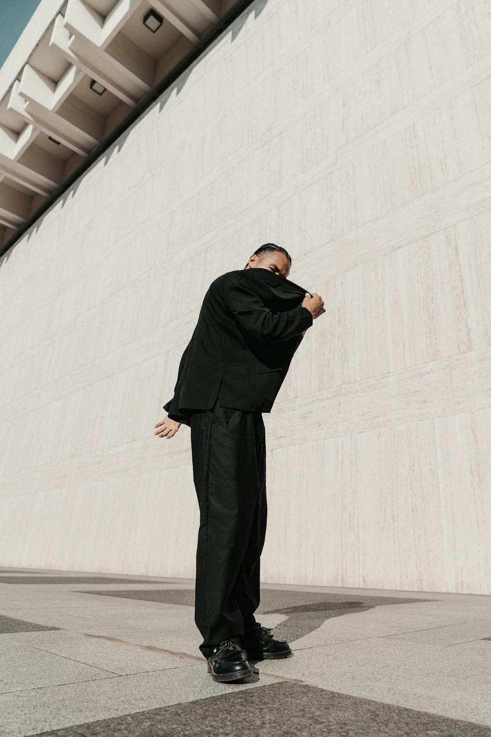 a man in a suit standing in front of a building