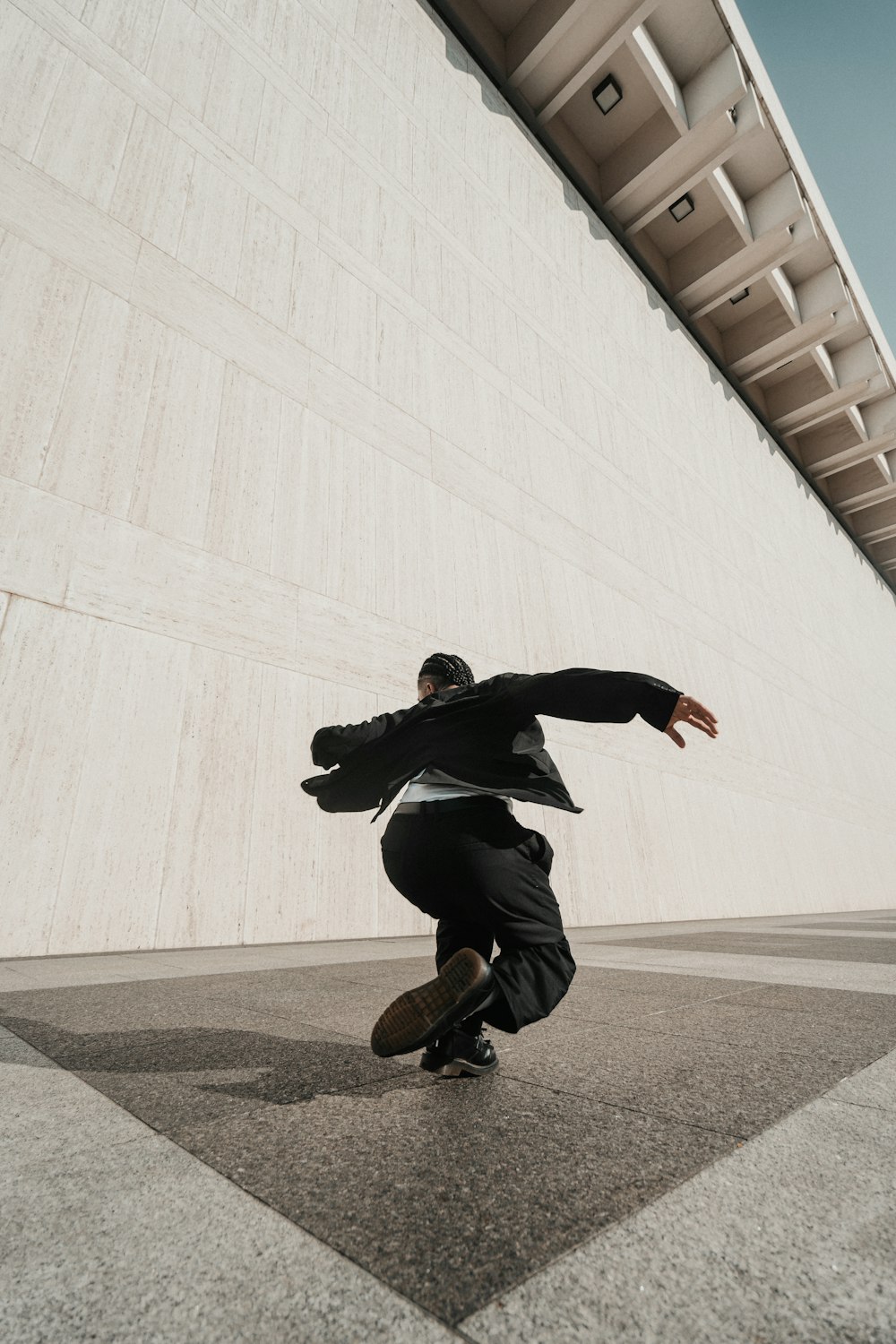 a man riding a skateboard next to a tall building