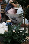 A person reading a newspaper in a cozy café.