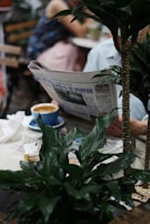 A person reading a newspaper in a cozy café.