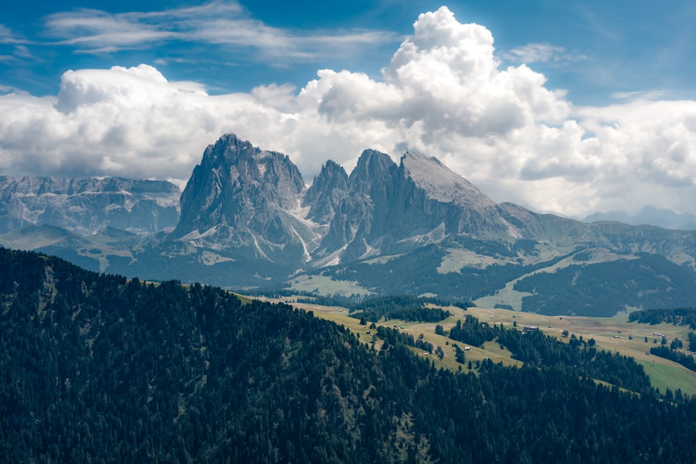 a view of a mountain range with trees and mountains in the background