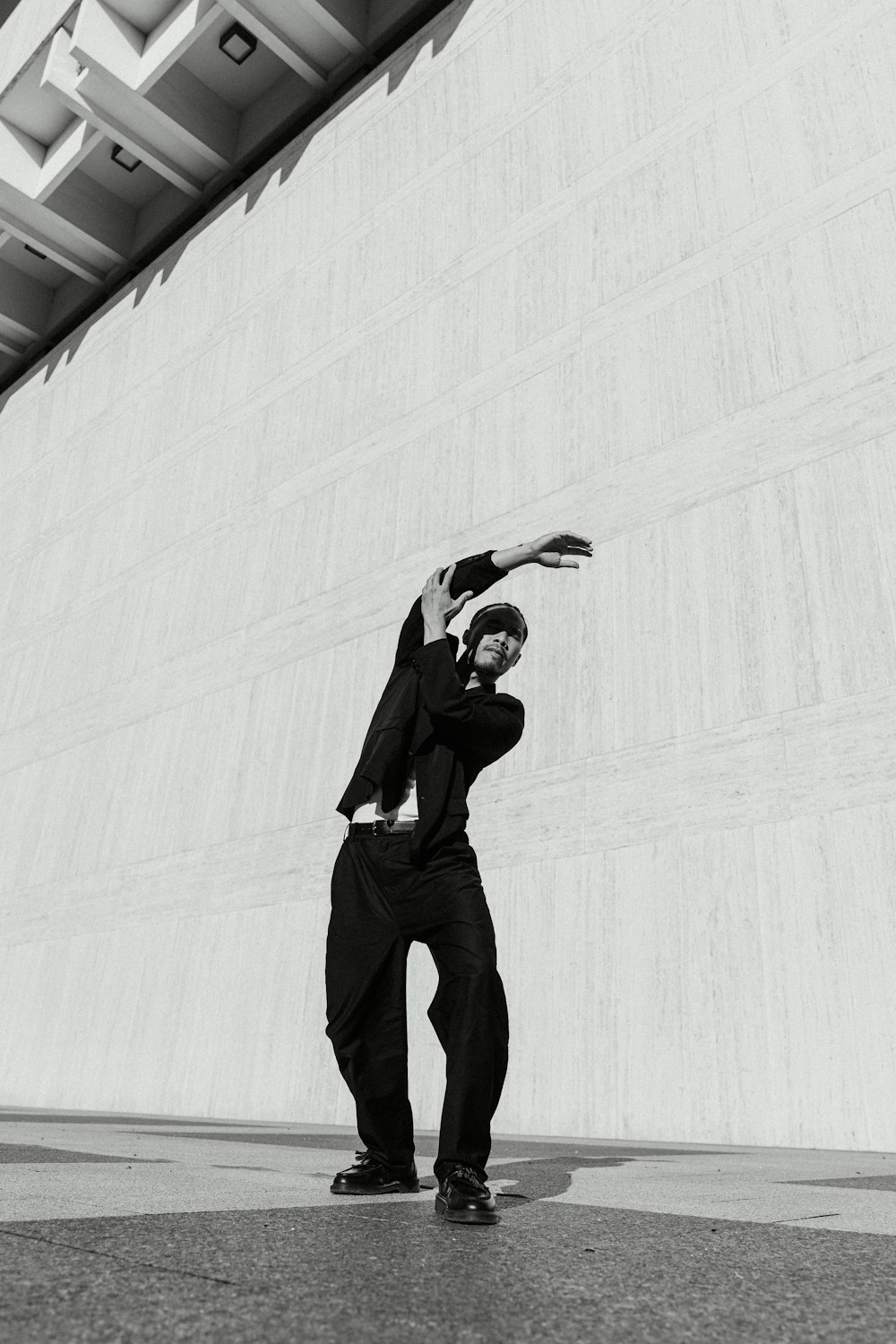 a man standing in front of a wall with his arms in the air