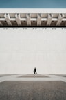 a person walking in front of a large building