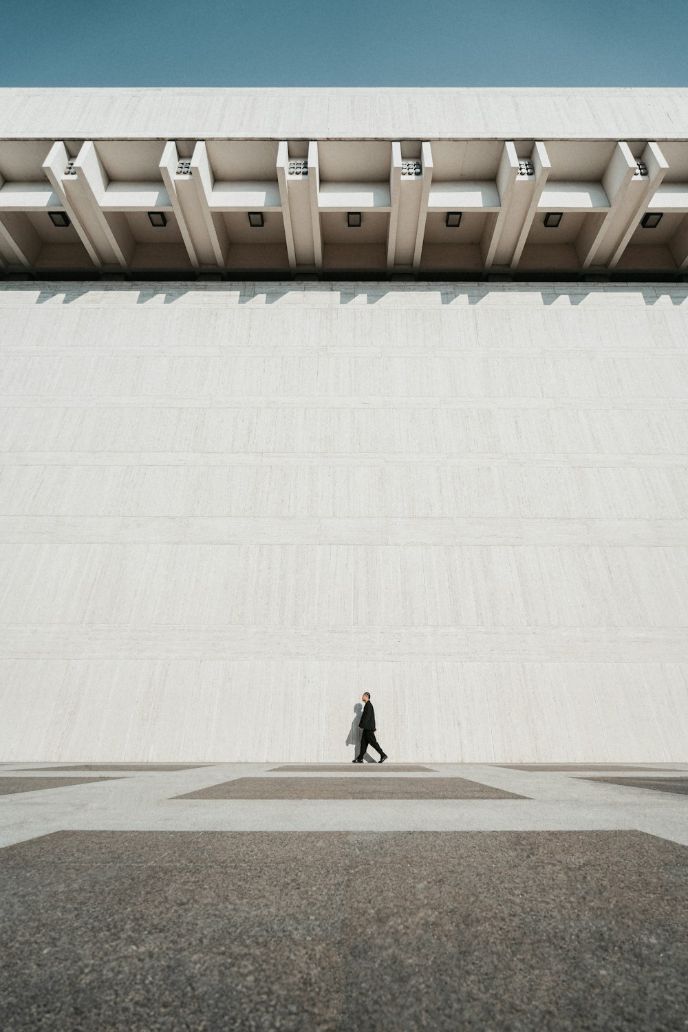 a person walking in front of a large building