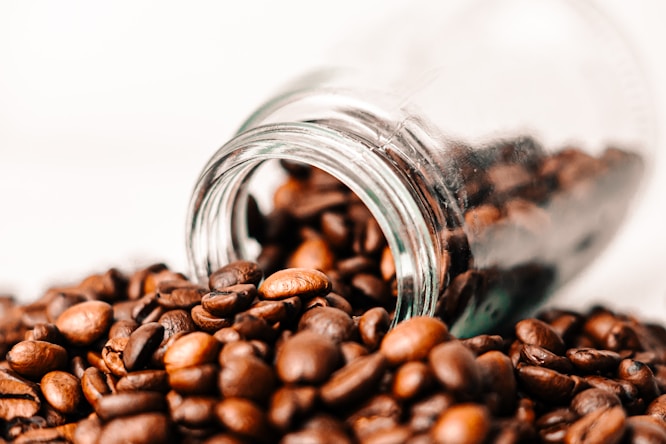 a glass jar filled with coffee beans on top of a table