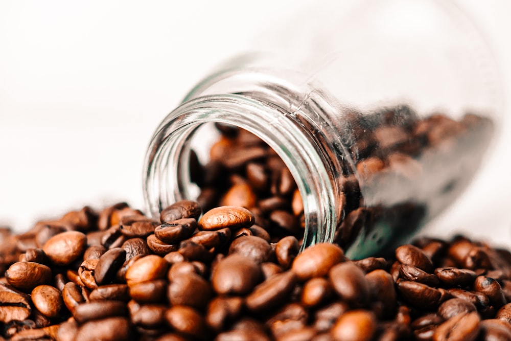 a glass jar filled with coffee beans on top of a table