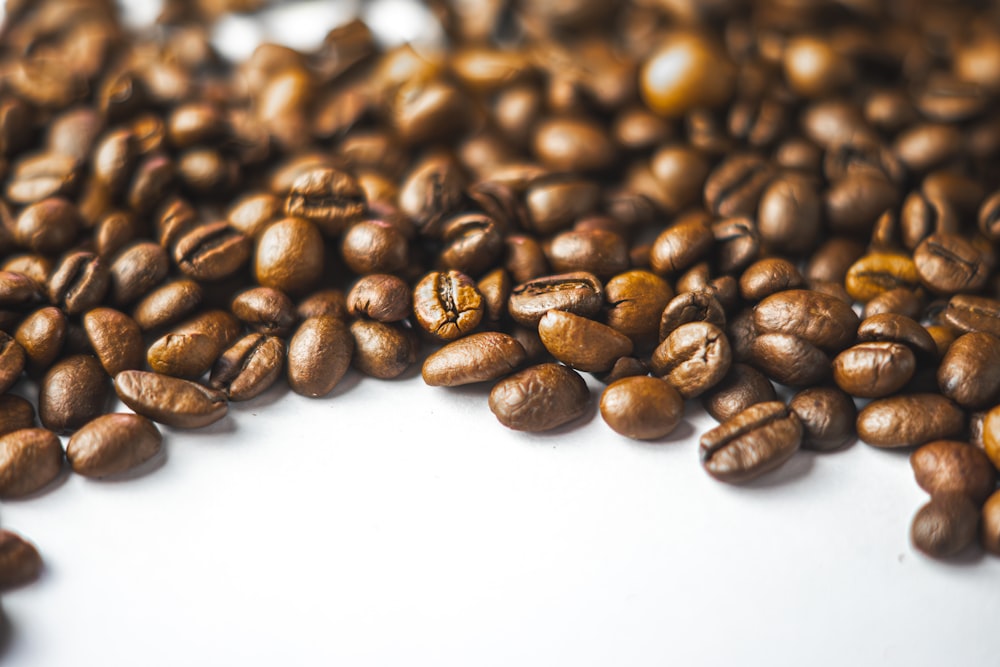 a pile of coffee beans sitting on top of a white table