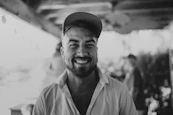 a black and white photo of a man smiling