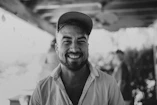 a black and white photo of a man smiling