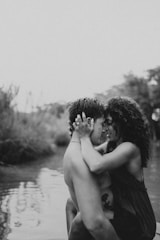Underwater shot of a couple embracing surrounded by tropical fish and coral reefs.