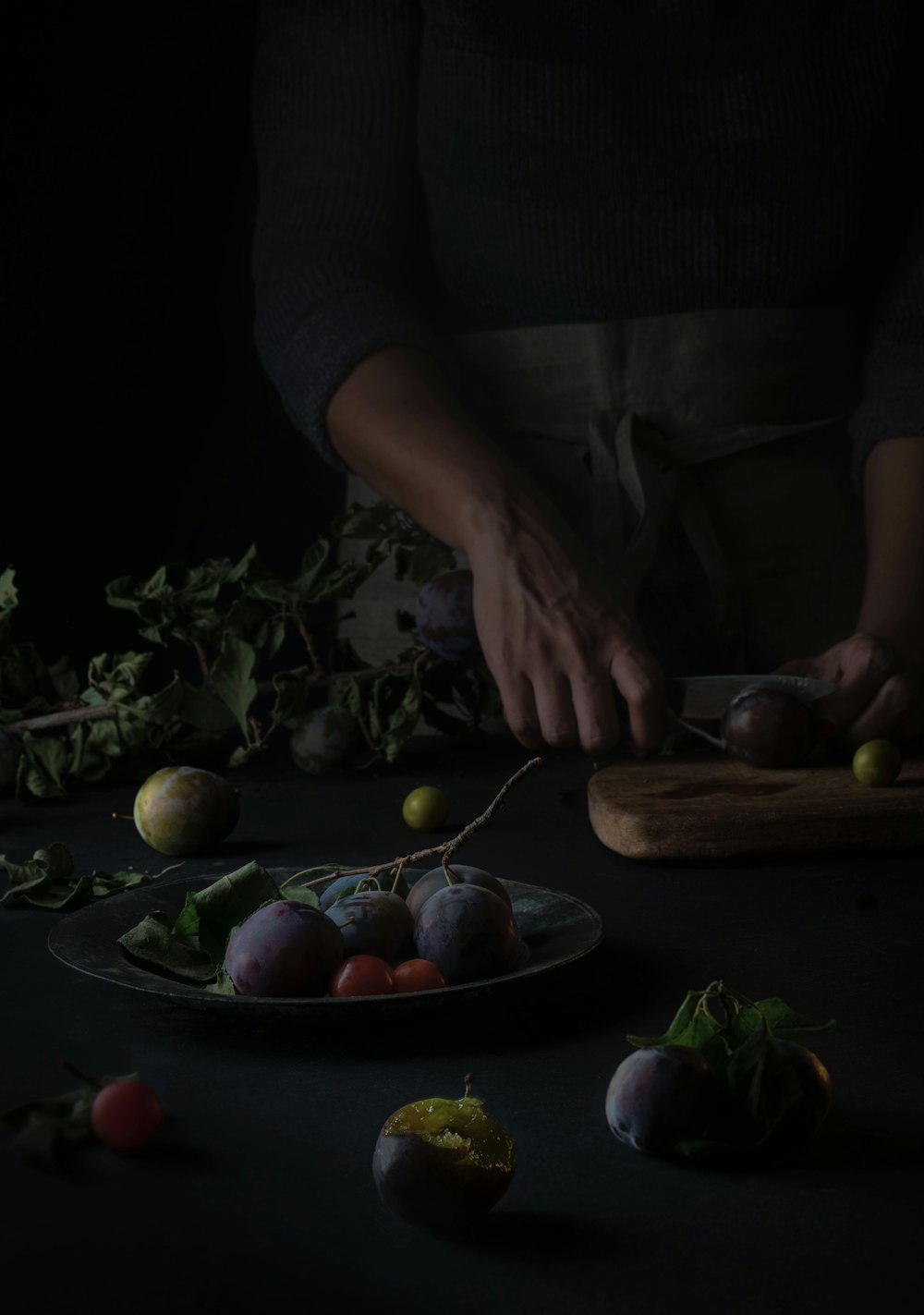 a person cutting vegetables on a plate on a table